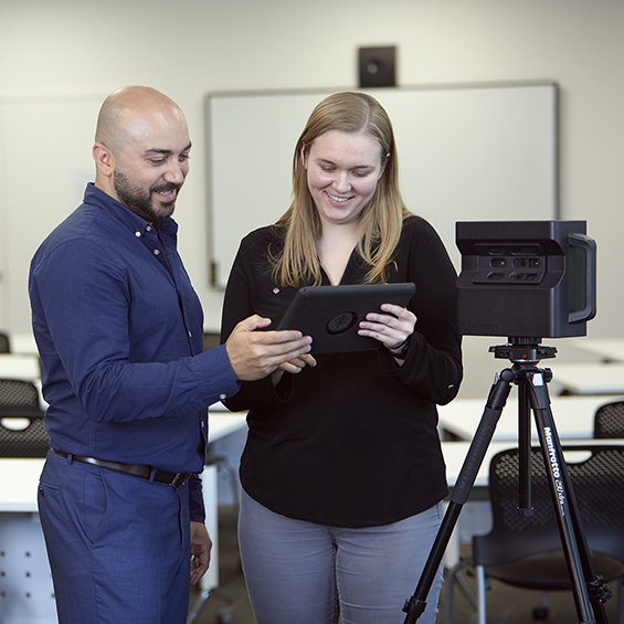 BIM staff looking at iPad with the Matterport 3D scanner