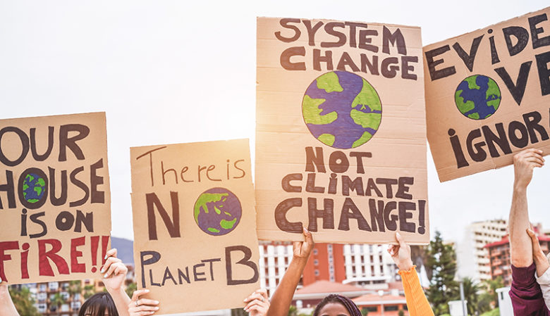 Group of demonstrators on road, young people from different culture and race fight for climate change - Global warming and enviroment concept - Focus on banners Photo of Group of demonstrators on road
