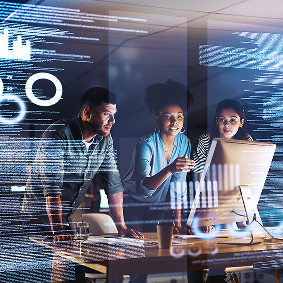Shot of a group of programmers working together on a computer code at night
