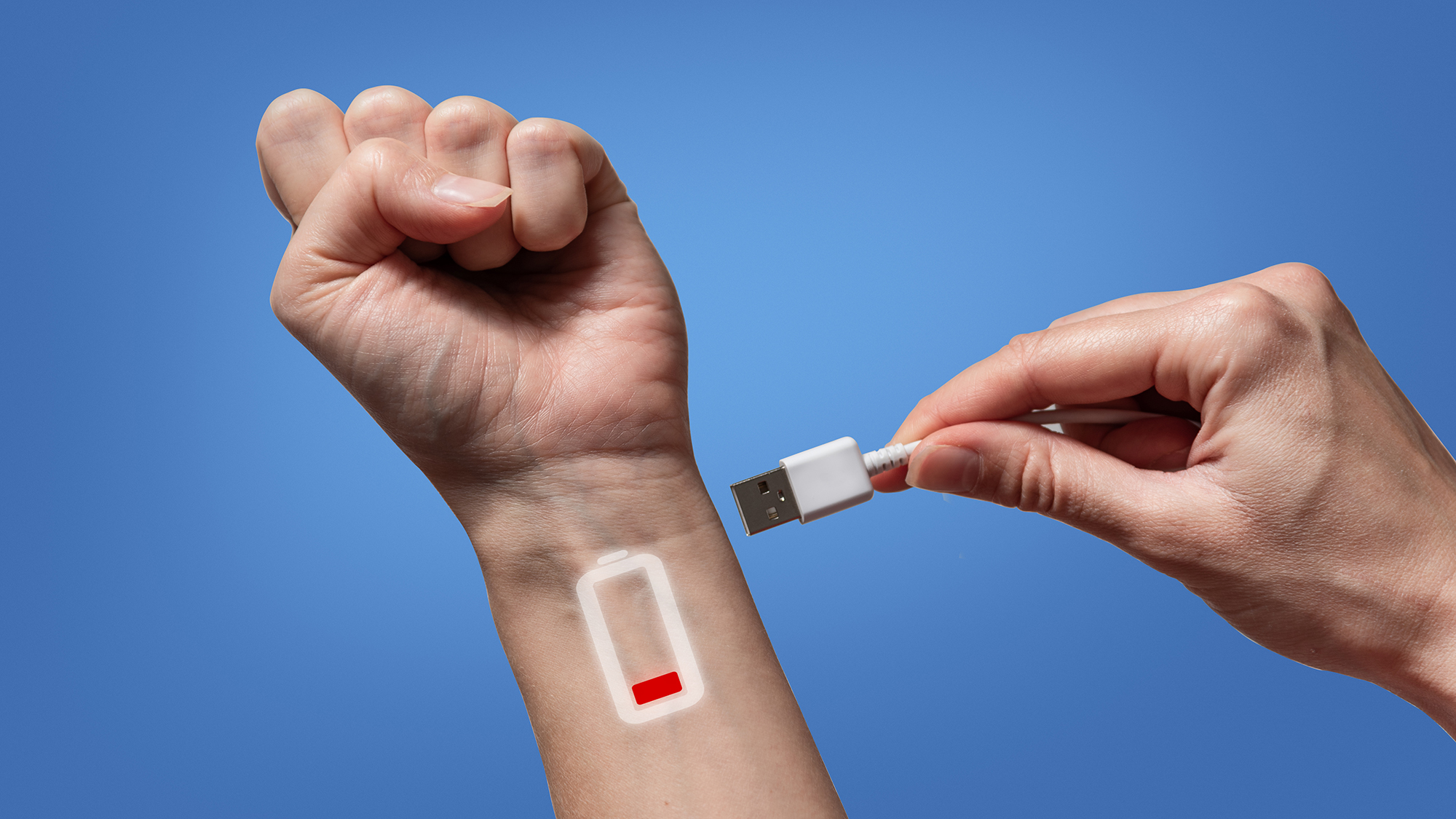 Plugging usb cable in hand with low battery symbol. Tired human concept. Recharging energy. Plugging usb cable in hand with low battery symbol. Tired human concept. Recharging energy.