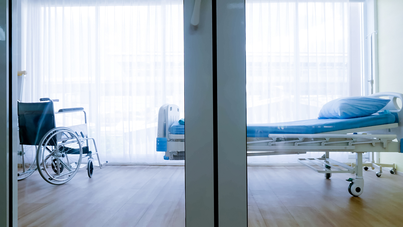 Bedroom for patient in a hospital, Empty bed and wheelchair on hospital ward. Bedroom for patient in a hospital, Empty bed and wheelchair on hospital ward