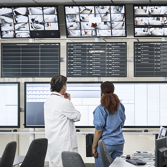 Doctors discussing over screens in control room