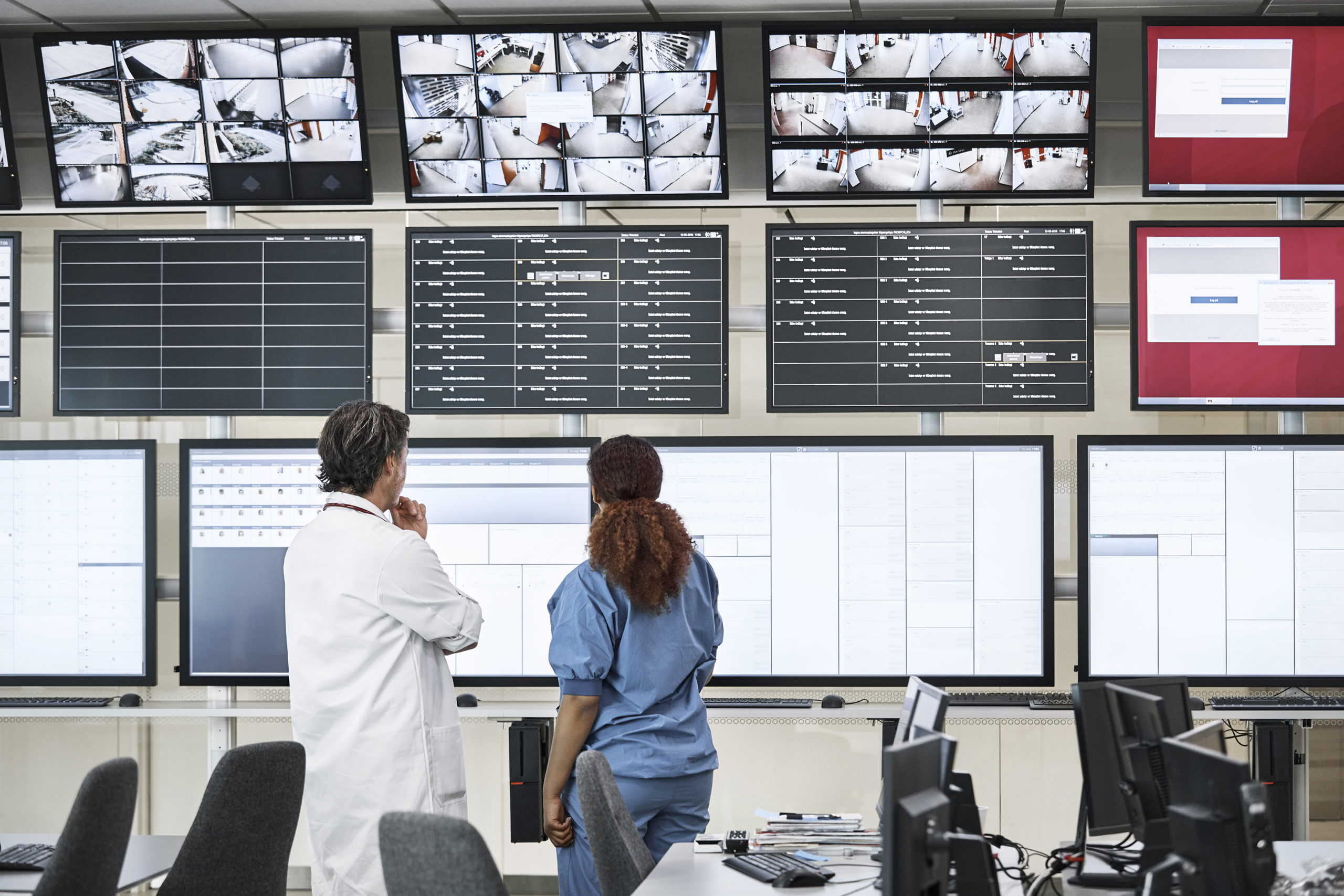 Doctors discussing over screens in control room