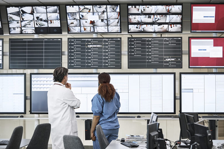 Doctors discussing over screens in control room