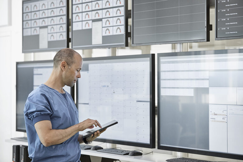 Doctor using digital tablet in control room