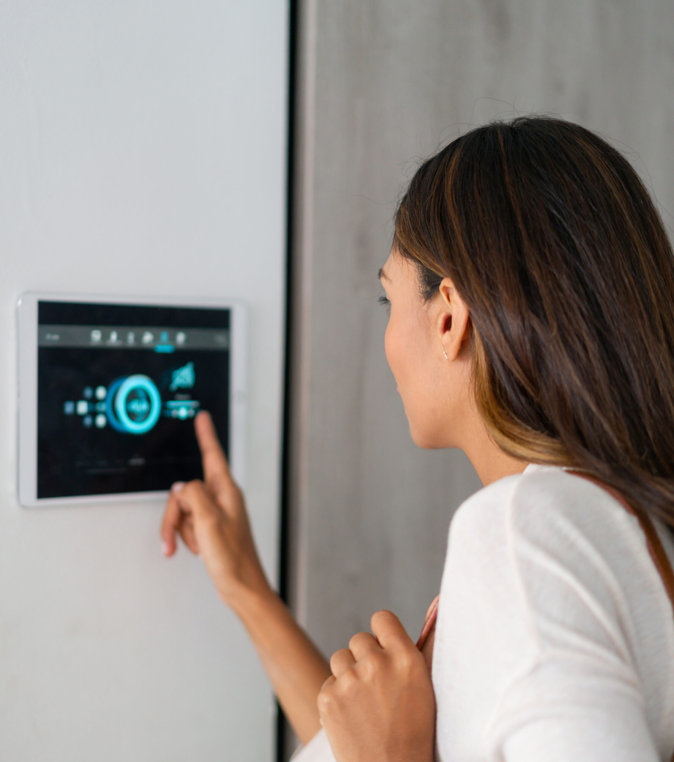 Woman locking her automated house using an app on a tablet computer Latin American woman locking the door of her automated house using an app on a tablet computer. **DESIGN ON SCREEN WAS MADE FROM SCRATCH BY US**